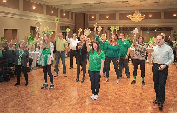 People holding green and gold paddles