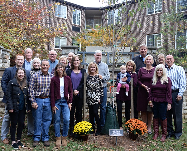 Board and family gathered around the tree